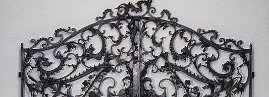 Detail of eighteenth-century wrought-iron German gate with elaborate arched crest and floral scrollwork